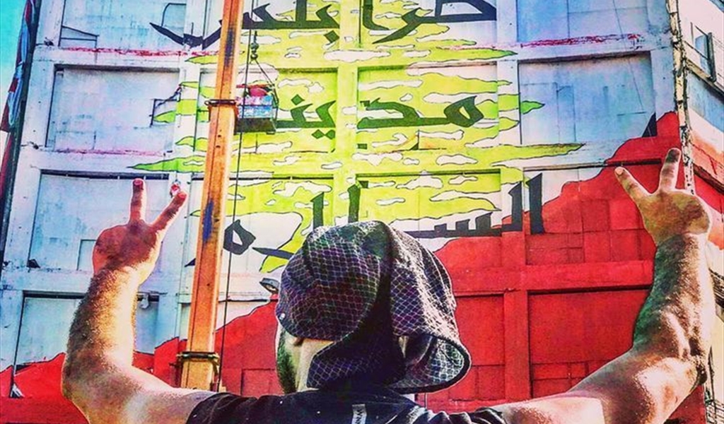 الفنان الأبرش أمام الجدارية