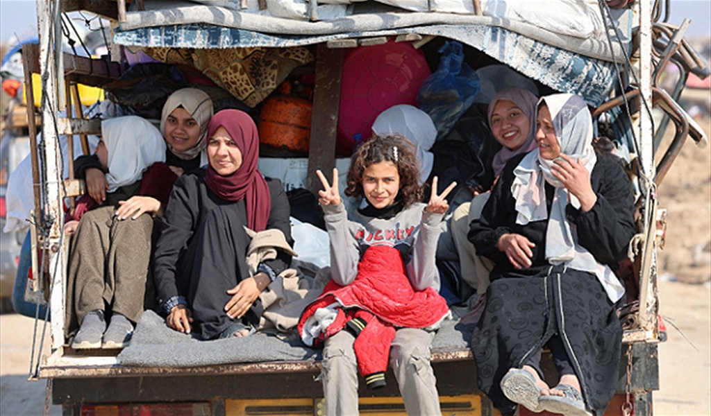 فتاة فلسطينية ترفع شارتي النصر خلال عودة عائلتها إلى شمال غزة