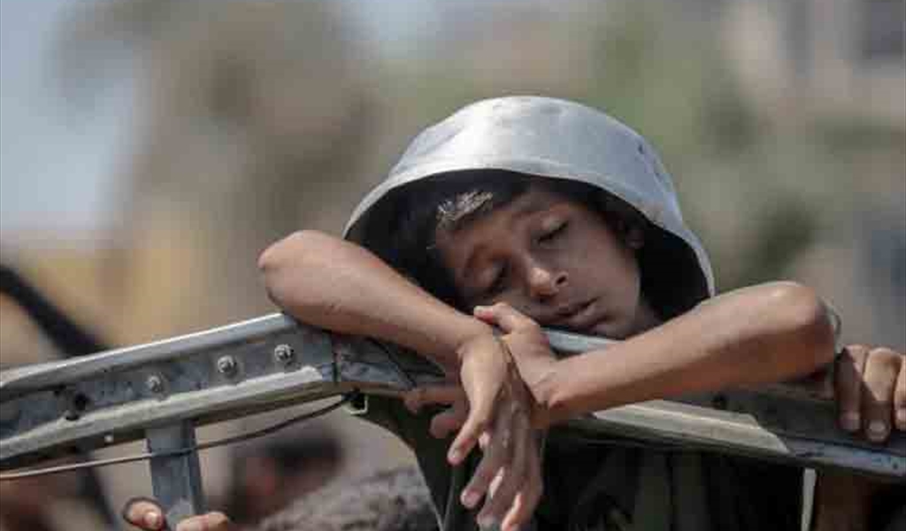 طفل فلسطيني يتضوّر جوعاً بانتظار الحصول على وجبة غذائية في غزة