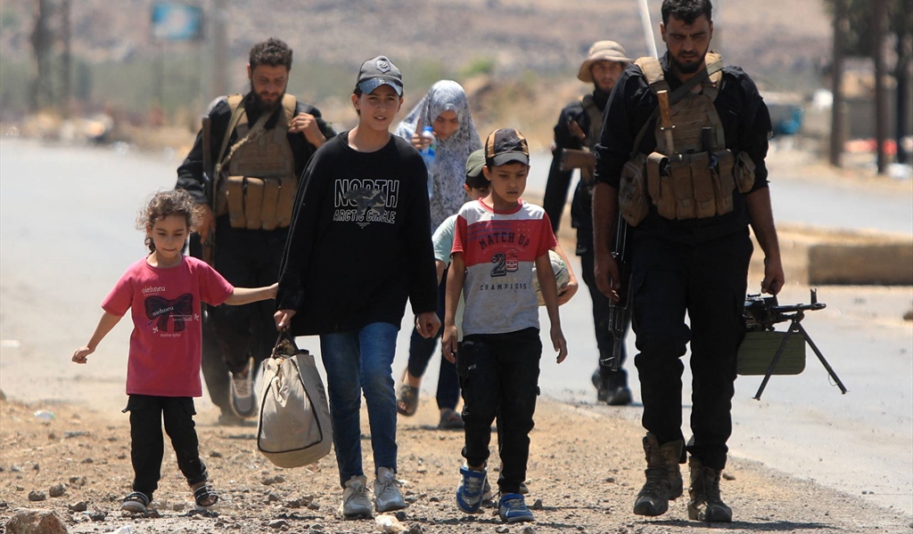 عائلة من البدو برفقة قوات الأمن خلال عمليات الإجلاء من مدينة السويداء