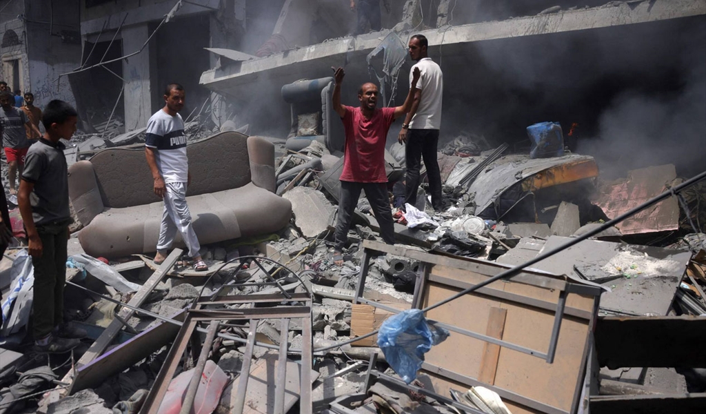 فلسطينيون فوق ركام منازلهم في حي الزيتون في جنوب مدينة غزة