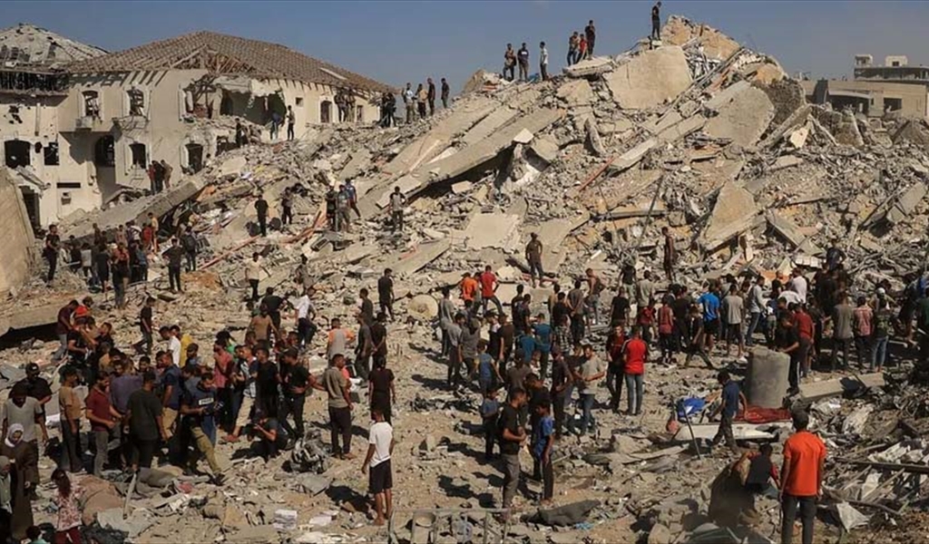 فلسطينيون فوق أنقاض مبنى سكني منهار بعد غارة إسرائيلية على مدينة غزة