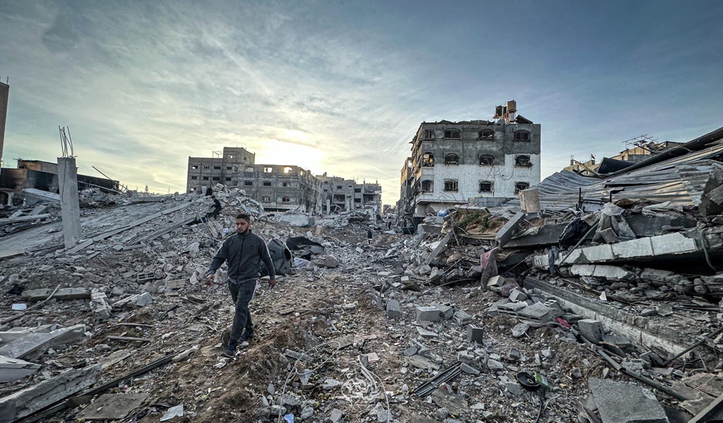 فلسطيني يمشي بين ركام المباني في غزة