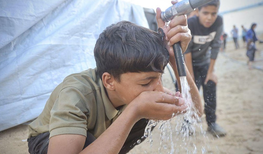 طفل فلسطيني يشرب من مياه خزان في احد مخيمات النازحين في غزة