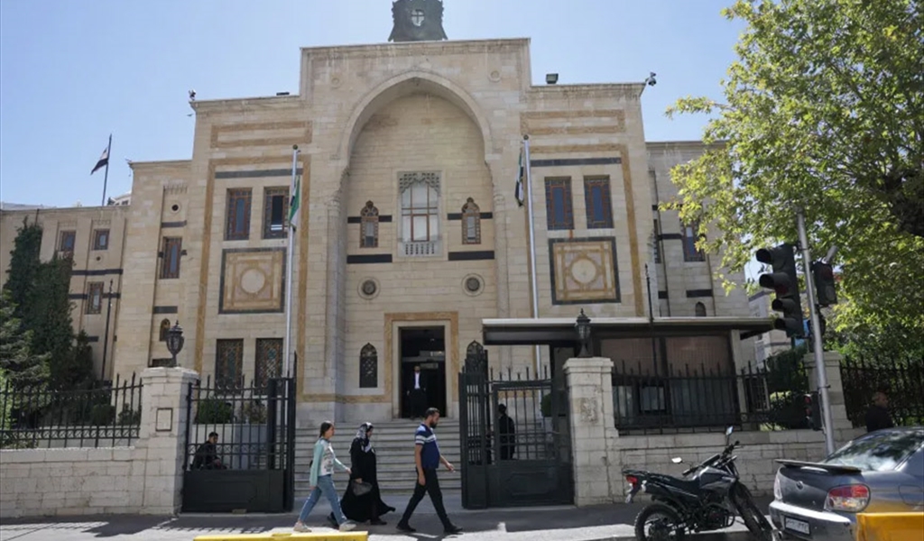 سوريون يمرون بجانب مجلس الشعب في دمشق