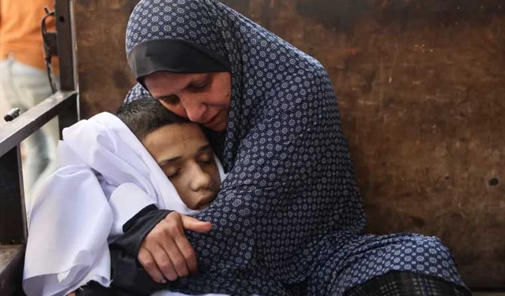فلسطينية تودع ابنها الشهيد بعد غارات الاحتلال على مدينة غزة
