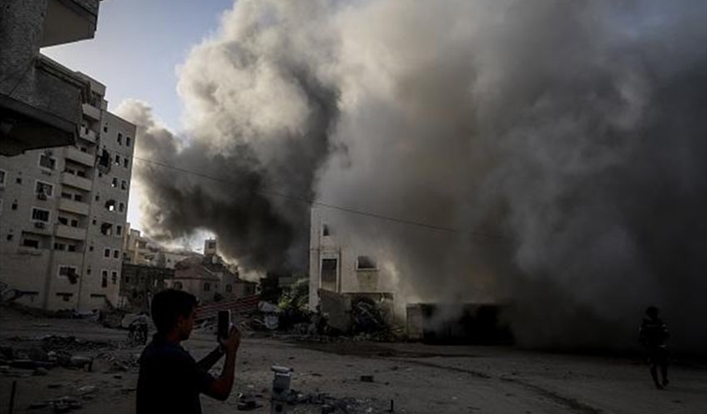 فتى فلسطيني يلتقط صورة بهاتفه لمنزل لحظة تدميره بمسيرة إسرائيلية في غزة