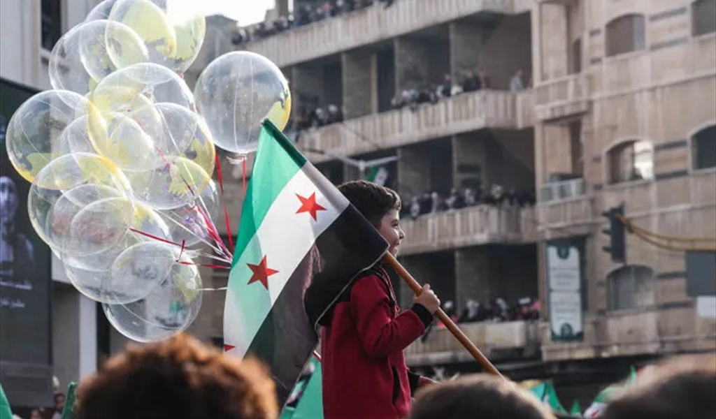 طفل سوري يشارك في الاحتفال الشعبي في ساحة الأمويين في دمشق
