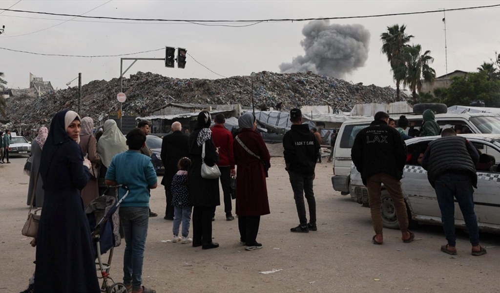 فلسطينيون يشاهدون تصاعد الدخان بعد استهداف المبنى امس