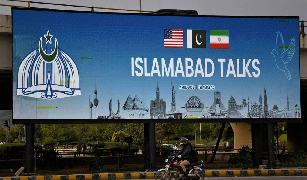 باكستاني يمر بجانب لوحة إعلان كبيرة عن مفاوضات إسلام آباد في جولتها الأولى