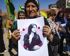 إمرأة تحمل صورة مهسا أميني خلال تظاهرة في الحسكة