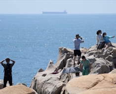 تايوانيون يشاهدون سفينة حربية صينية خلال المناورات قرب المياه الاقليمية للجزيرة
