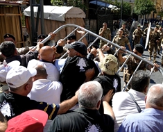 العسكريون المتقاعدون ينزعون العائق الحديدي، ويهمون بالدخول إلى باحة المجلس النيابي (محمود يوسف)