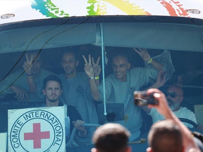 أسرى فلسطينيون محررون من سجون الاحتلال يرفعون شارات النصر لحظة دخولهم  إلى أرض القطاع في حافلات للصليب الأحمر