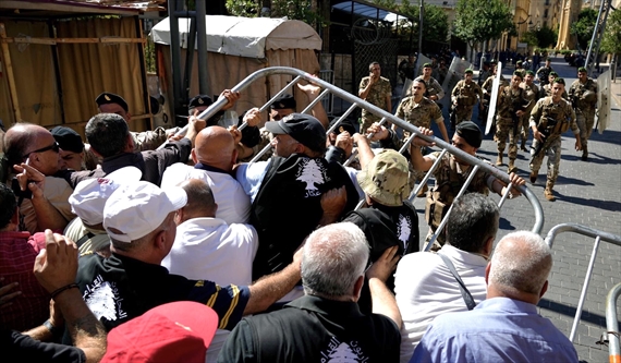 العسكريون المتقاعدون ينزعون العائق الحديدي، ويهمون بالدخول إلى باحة المجلس النيابي (محمود يوسف)