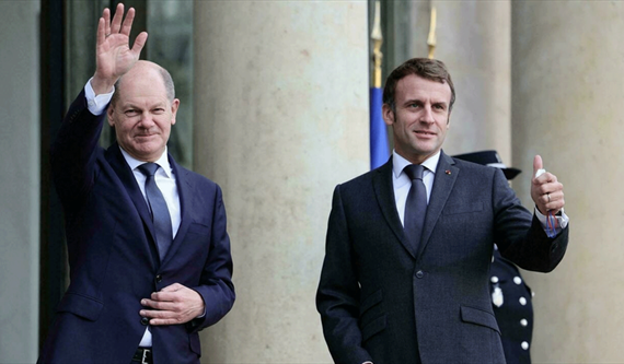 الرئيس الفرنسي إيمانويل ماكرون والمستشار الألماني أولاف شولتز يلوحان للصحفيين قبيل اجتماع في قصر الإليزيه في باريس، فرنسا، 10 كانون الأول\ديسمبر 2021